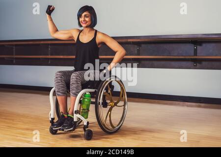 Eine querschnittsgelähmte Frau, die eine Pause in einem Gymnasium macht, nachdem sie in einer Erholungseinrichtung gearbeitet hat: Sherwood Park, Alberta, Kanada Stockfoto