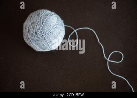 Ball aus blauem Garn auf dunklem Hintergrund Stockfoto