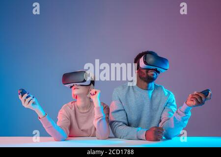 Angenehmes Paar mit einem Game-Controller, während mit einer Pause am Tisch, Nahaufnahme Foto, isolierten blauen Hintergrund, Lebensstil Stockfoto