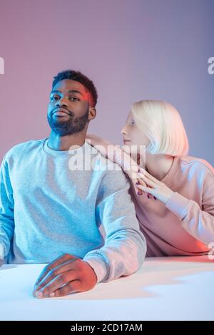 Arroganter junger Mann nicht bemerken, ein schönes blondes Mädchen whoile mit einer Pause am Tisch, Nahaufnahme Foto Stockfoto