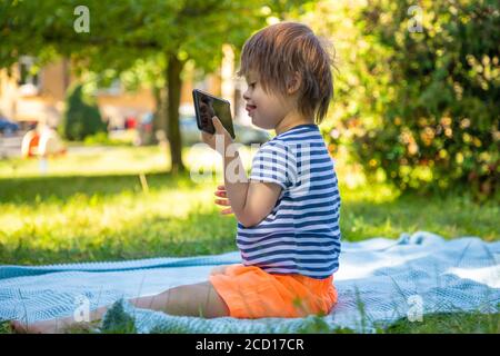 Portrait des Jungen mit Down-Syndrom spielen im Sommer Tag in der Natur Stockfoto