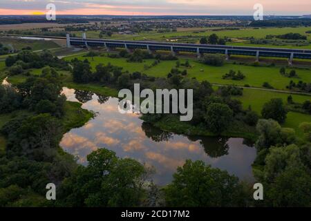 Magdeburg, Deutschland. Juli 2020. Wolken spiegeln sich bei Sonnenuntergang in einem alten Elbuarm vor der Magdeburger Wasserstelle. Der Mittellandkanal führt hier in einer Trogbrücke über die Elbe. Mit einer Länge von 918 Metern ist sie die größte Kanalbrücke Europas. (Luftaufnahme mit Drohne) Quelle: Stephan Schulz/dpa-Zentralbild/ZB/dpa/Alamy Live News Stockfoto