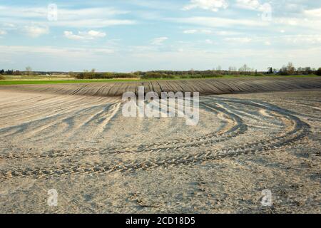 Spuren des Traktors im gepflügten Feld Stockfoto