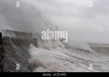 Stormy Seas Batter Porthcawl Pier und Leuchtturm. Südwales, Großbritannien Stockfoto