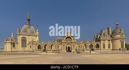 Weitwinkelansicht auf der Fassade von Schloss chantilly, frankreich, an einem sonnigen Tag mit klarem blauen Himmel Stockfoto