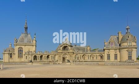 Weitwinkelansicht auf der Fassade von Schloss chantilly, frankreich, an einem sonnigen Tag mit klarem blauen Himmel Stockfoto