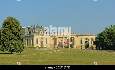 Fassade der Stallungen von Schloss chantilly, jetzt beherbergt ein Pferdemuseum, mit Park an einem sonnigen Tag mit klarem blauen Himmel Stockfoto