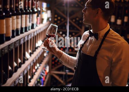 Erfahrene Sommelier besitzen nicht nur Wein Etikette, sondern auch Weinprobe Fähigkeiten genießen Geschmack und Geschmack von edlem Getränk. Stockfoto