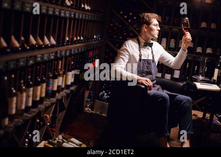 Weinkritiker schätzen Farbe Tönung, Qualität und Sedimente von Getränken im Spirituosenladen. Stockfoto