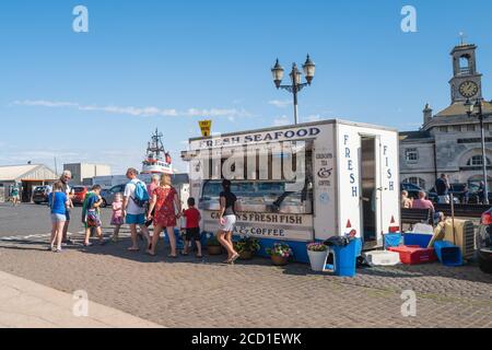 Ramsgate, Großbritannien - 20. August 2020 Besucher und Einheimische kaufen Meeresfrüchte an einem Stand neben dem Royal Harbour. Stockfoto