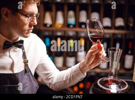 Erfahrene Sommelier besitzen nicht nur Wein Etikette, sondern auch Weinprobe Fähigkeiten genießen Geschmack und Geschmack von edlem Getränk. Stockfoto