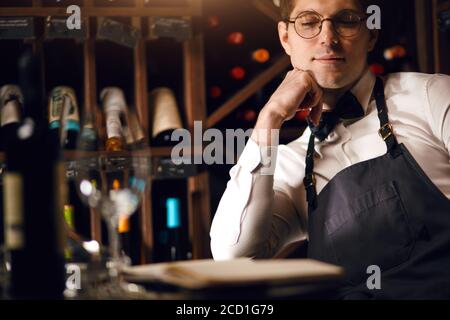 Professionelles Verkaufspersonal - Sommelier hilft, das richtige Produkt nur für Kunden zu wählen. In Wine Boutique Kunden willkommen, um Produkt, das die schmecken Stockfoto