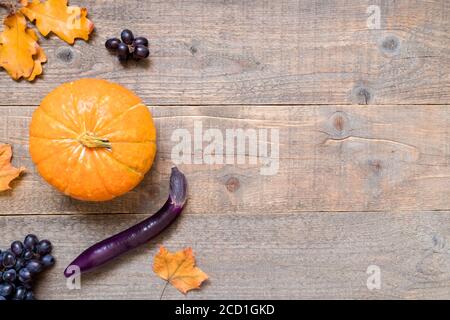 Herbsthintergrund mit gelben Blättern und Gemüse. Rahmen der Herbsternte auf gealtertem Holz mit Kopierraum. Draufsicht und Flachlage Stockfoto