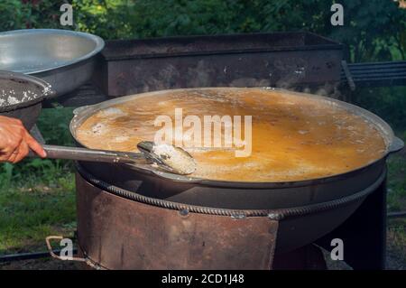 Nationale Nahrung der östlichen Völker. Pilaf in einem großen Kessel. Reis und Lamm über dem Feuer gekocht. Kochen von nationalen Speisen Stockfoto