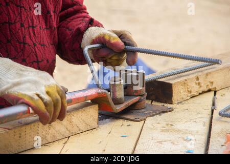 Biegen Verstärkung Metall rebar. Arbeiter mit Biegerebenmaschine für die Bewehrung in den Bauarbeiten Stockfoto