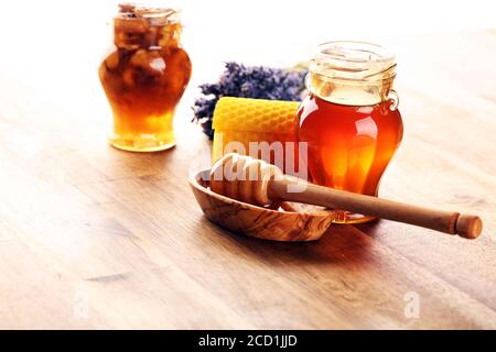 Honig im Glas mit Honig Dipper auf rustikalem Holzhintergrund Stockfoto