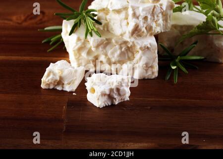 Griechischer Käsefeta mit Kräutern auf einem rustikalen Tisch Stockfoto