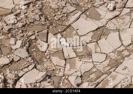 Der Boden verkrustet sich auf dem Feld und zeigt Risse, wenn Schlamm austrocknet und Feuchtigkeit verdunstet. Für die Bodenwissenschaft, Dürre in Großbritannien, Wasserknappheit, Risse bilden sich. Stockfoto