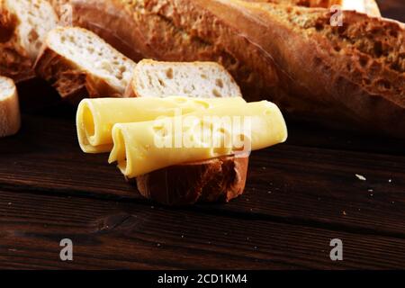 Brot mit Käsescheiben für den Mittagstisch. Teilen Antipasti auf Party oder Sommer Picknick Zeit über Holz rustikalen Hintergrund. Stockfoto