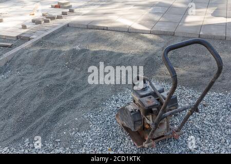 Manuelle Stampfmaschine zum Verdichten von Boden auf einer Baustelle. Ausrüstung für Bauarbeiten. Handwerkzeug. Stockfoto