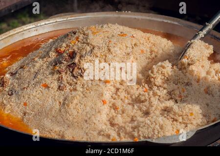 Usbekischer Pilaf in einem großen Kessel. Kochen eines nationalen usbekischen Gericht. Nationale Küche der Völker der Welt. Stockfoto