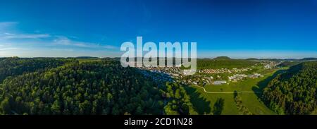 Inspirierende Luftlandschaft, sommerlicher grüner Wald und eine schöne Stadt in einem Tal am Erholungsgebiet der Schwäbischen Alb in deutschland. Stockfoto