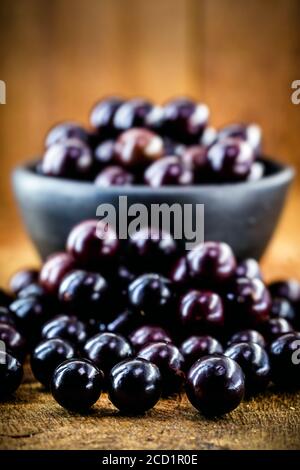 Brasilianische Frucht genannt jaboticaba oder jabuticaba, ist die einheimische Traube von Brasilien. Plinia cauliflora Arten, auf einem rustikalen Tisch, exotische Früchte, anti-infla Stockfoto