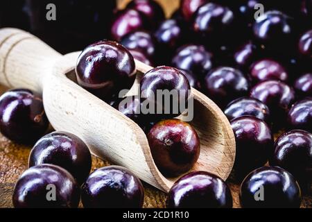 Brasilianische Frucht genannt jaboticaba oder jabuticaba, ist die einheimische Traube von Brasilien. Plinia cauliflora Arten, auf einem rustikalen Tisch, exotische Früchte, anti-infla Stockfoto