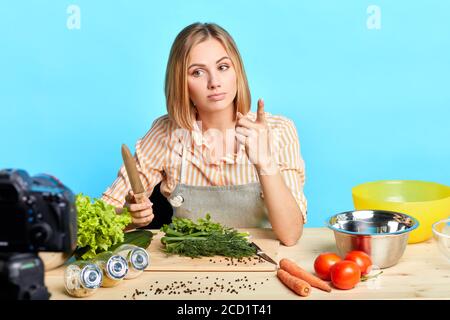 Junge talentierte Ernährungswissenschaftlerin erzählt Geheimnisse der gesunden Ernährung, um ihre Anhänger, macht frisch schmackhafte Gericht mit Bio-Gemüse, kochet Mahlzeit mit lo Stockfoto