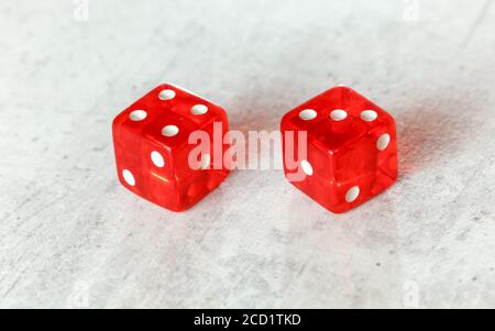 Zwei durchscheinende rote Würfelwürfelwürfelchen auf weißem Brett, das Natur zeigt Oder Seven Out (Nummer 4 und 3) Stockfoto