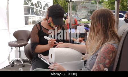 Vista, CA / USA - 1. August 2020: Ein Nagelstudio hat seinen Betrieb nach draußen verlegt, um zu Zeiten von Covid-19 nicht wieder schließen zu müssen. Stockfoto