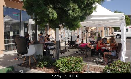 Vista, CA / USA - 1. August 2020: Ein Nagelstudio hat seinen Betrieb nach draußen verlegt, um zu Zeiten von Covid-19 nicht wieder schließen zu müssen. Stockfoto