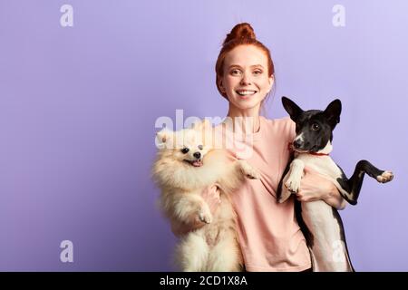 Attraktive junge lächelnde Ingwer Frau umarmt ihre Hunde, Liebe und Freundschaft Konzept. Copy space. Beste Freunde Stockfoto