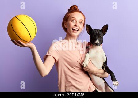 Überglücklich aufgeregt Ingwer Mädchen Lehre ihren Hund mit einem Ball spielen, Nahaufnahme Porträt, Trainingsprozess, Vergnügen, Glück, Studio erschossen Stockfoto