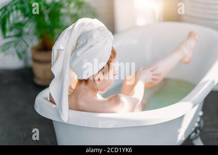 Nach einem ganzen Tag, was besser für eine schöne Frau zu behandeln, als in der warmen Badewanne entspannen und sich verwöhnen. Stockfoto