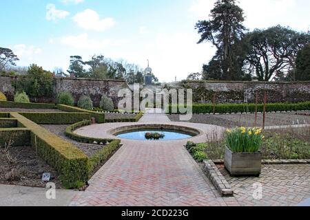 Ein formeller Garten in England mit einem runden Teich umgeben Durch Ziegelsteinpflaster Stockfoto