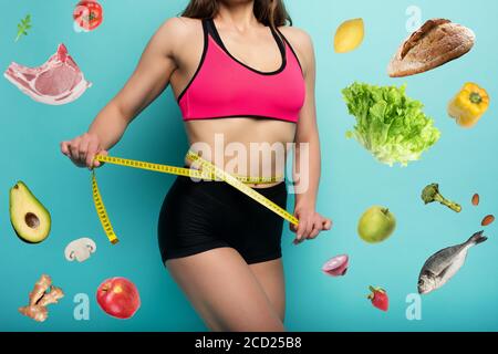 Determinated Sport Frau hat eine ausgezeichnete körperliche Form und messen mit dem Meter. Cyanfarbener Hintergrund Stockfoto