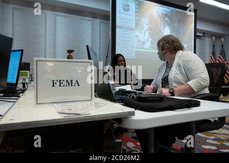 Austin, Texas, USA. August 2020. Texanische Beamte sammeln Daten im staatlichen Emergency Operations Center (EEOC) in einem lokalen Hotel, da Gouverneur Greg Abbott (nicht gezeigt) die Presse über die Vorbereitungen von Texas auf den Hurrikan Laura informiert, der am Donnerstag im Osten von Texas und an der Küste von Louisiana landen soll. Abbott mobilisierte Hunderte von staatlichen Ressourcen, da Texaner sich an die extremen Schäden erinnern, die der Hurrikan Harvey 2017 angerichtet hatte. Quelle: Bob Daemmrich/ZUMA Wire/Alamy Live News Stockfoto