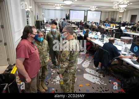 Austin, Texas, USA. August 2020. Texanische Beamte sammeln Daten im staatlichen Emergency Operations Center (EEOC) in einem lokalen Hotel, da Gouverneur Greg Abbott (nicht gezeigt) die Presse über die Vorbereitungen von Texas auf den Hurrikan Laura informiert, der am Donnerstag im Osten von Texas und an der Küste von Louisiana landen soll. Abbott mobilisierte Hunderte von staatlichen Ressourcen, da Texaner sich an die extremen Schäden erinnern, die der Hurrikan Harvey 2017 angerichtet hatte. Quelle: Bob Daemmrich/ZUMA Wire/Alamy Live News Stockfoto