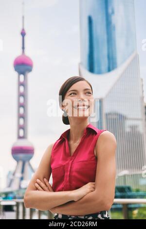 Business in China - chinesische Geschäftsfrau zuversichtlich Blick auf die Skyline von Shanghai im Finanzviertel Pudong. Junge professionelle asiatische multirassische Stockfoto