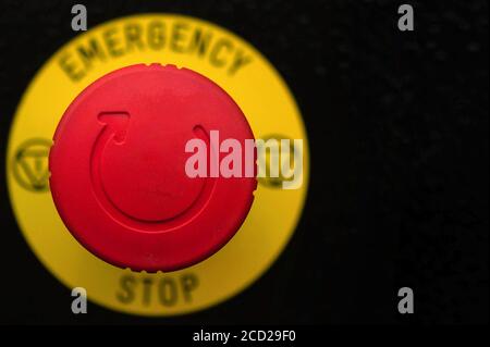 Roter Notausschalter auf schwarzem Bedienfeld. Stopp Stockfoto