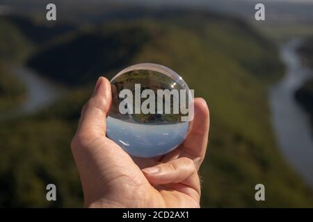 Nahaufnahme einer Glaskugel mit umgekehrter Ansicht Einer Berglandschaft Stockfoto