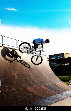 BMX Stunt vertikal. Ein Profi-Radfahrer Extreme Radfahrkonzept. Dert springen. BMX Vertikal-Barspin-Sprung. BMX Freestyle Vert Stunt. Halframp. Set Von Skatepark Element Stockfoto