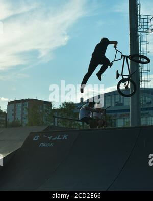 BMX Stunt vertikal. Ein Profi-Radfahrer Extreme Radfahrkonzept. Dert springen. BMX Vertikal-Barspin-Sprung. BMX Freestyle Vert Stunt. Halframp. Set Von Skatepark Element Stockfoto