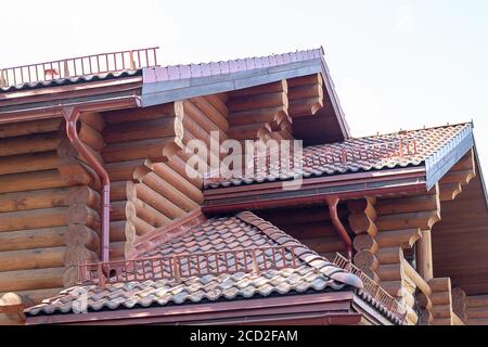Blockhaus gefliestes Dach. Nahaufnahme Detail der neuen modernen Holz warm ökologischen Cottage House Top mit Schindled braun Dach. Professionell gemacht Schreinerei ein Stockfoto