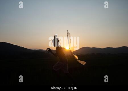 Peking, Indonesien. August 2020. Ein Kind läuft auf einem Reisfeld in Bogor in der Provinz West Java, Indonesien, um einen Drachen zu fliegen, 25. August 2020. Quelle: Veri Sanovri/Xinhua/Alamy Live News Stockfoto