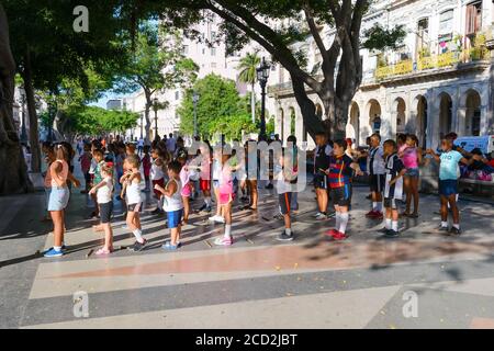Gruppe von Kindern, die in Paseo del Prado, Havanna, Kuba spielen. Kubanische Kinder haben Spaß auf einem Boulevard in der Nähe des Stadtzentrums. Aktivitäten zur Integration in die Community. Stockfoto
