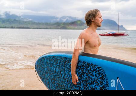 Paddleboard Mann geht Paddleboarding auf hawaii Ocean Beach. Stand Up Paddle Boarding im sommer auf hawaii. Stockfoto