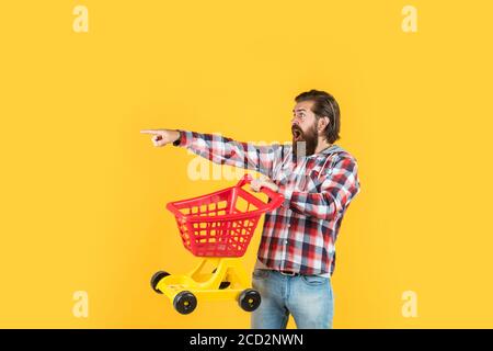 Voll einkaufen. Wochenende auf den Kauf von Produkten. Freut sich erfolgreiche Einkäufe. Brutal reifen Hipster gehen einkaufen. Seine Zeit, den Warenkorb zu füllen. Mann gehen einkaufen. Lustiger Mann mit kleinen Warenkorb. Stockfoto