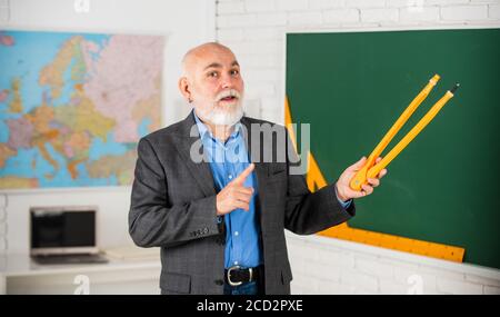 Älterer Mann Lehrer verwenden Kompass Werkzeug. Bärtiger Lehrer Mann zeichnen mit Kompass auf Tafel. Zurück zur Schule. Mathematische Grafik-Tools Konzept. Auf dem Weg zum Wissen. Studieren Sie Mathematik, um gute Ergebnisse zu erzielen. Stockfoto